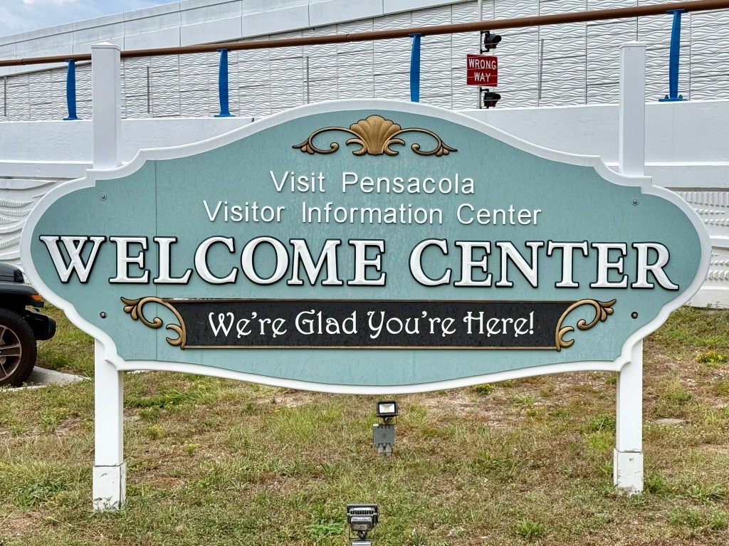 Sign reads: "Visit Pensacola Visitor Infromation Cetner Welcome Center "We're Glad You're Here!""